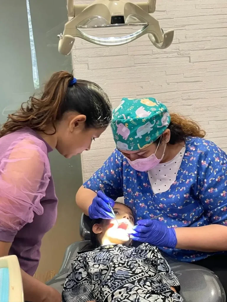 Pediatric dentist in Kandivali smiling with child, transparent aligners, teeth whitening near me.